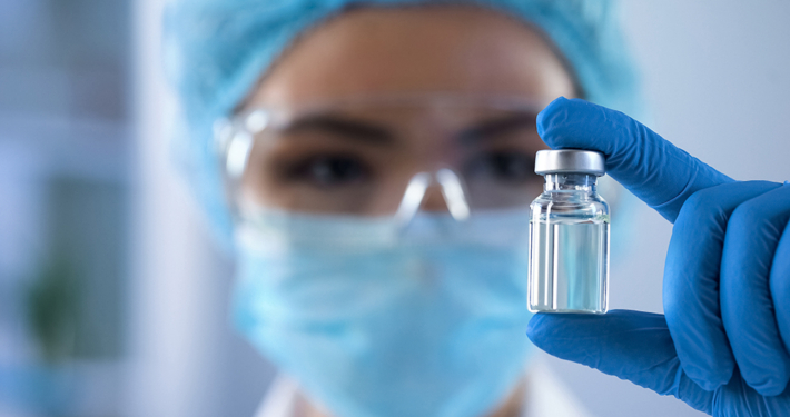 Scientist looking at ampoule in the bio tech industry